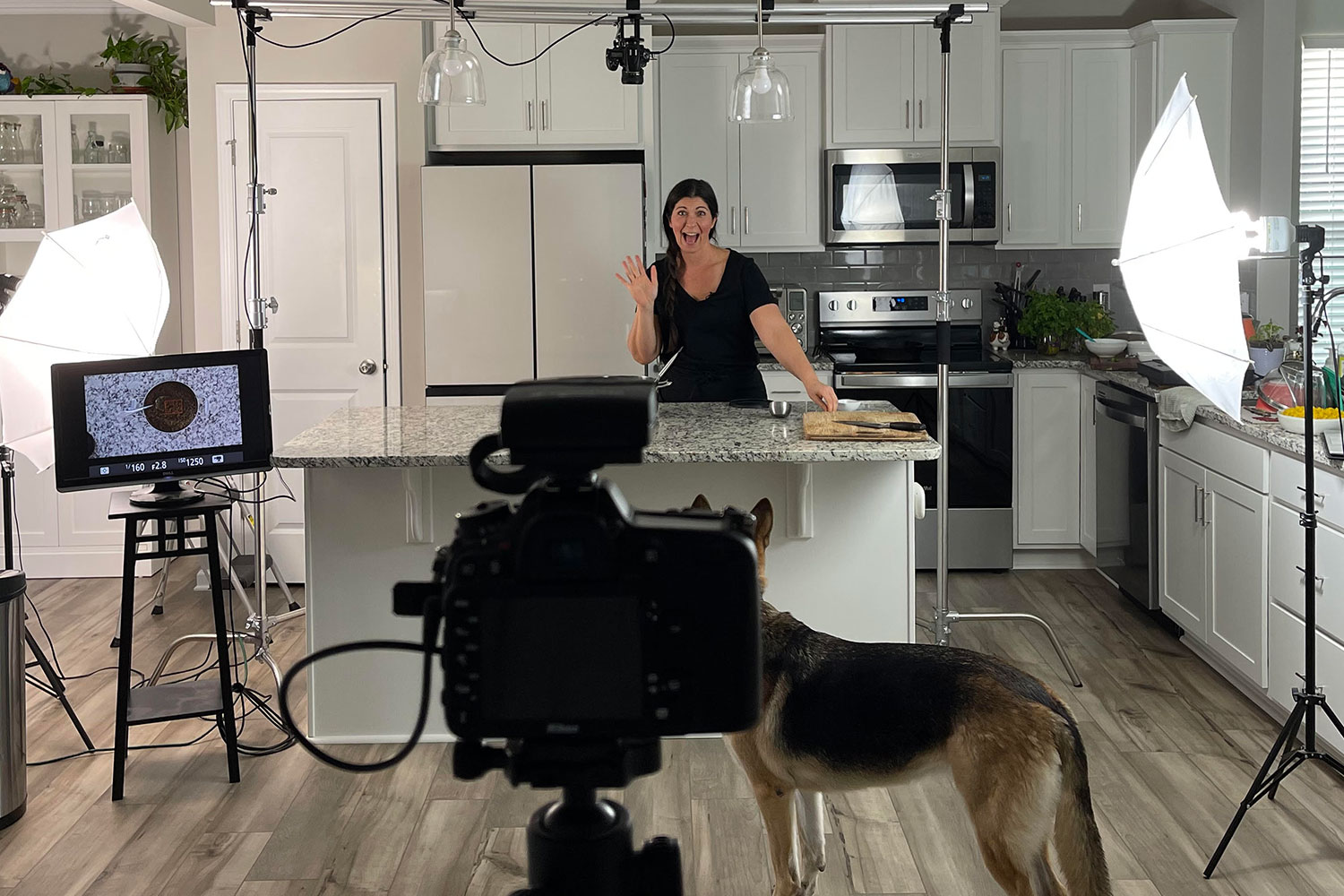 Samantha behind camera equipment in her kitchen.
