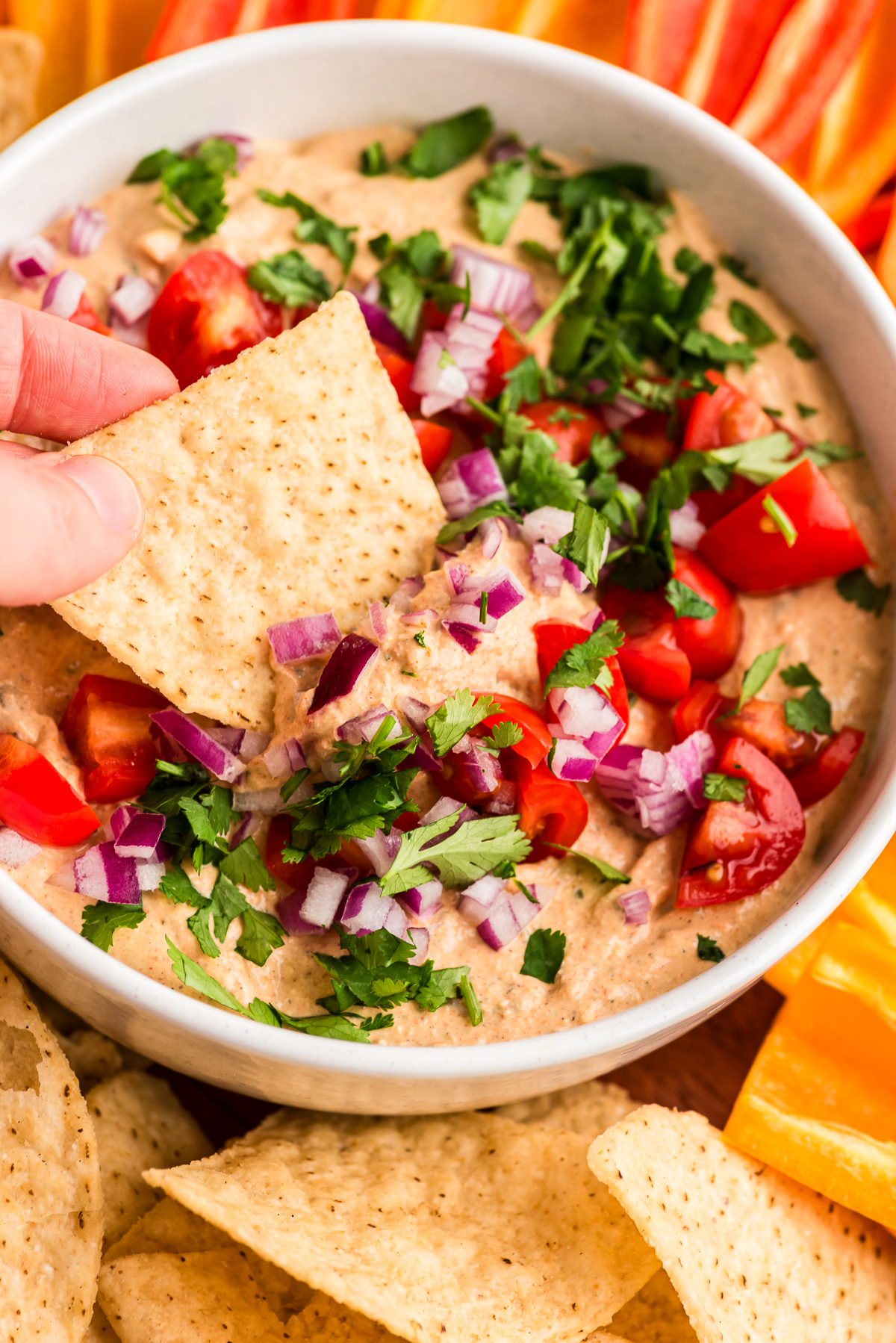 Tortilla chip being dipped in cottage cheese taco dip.