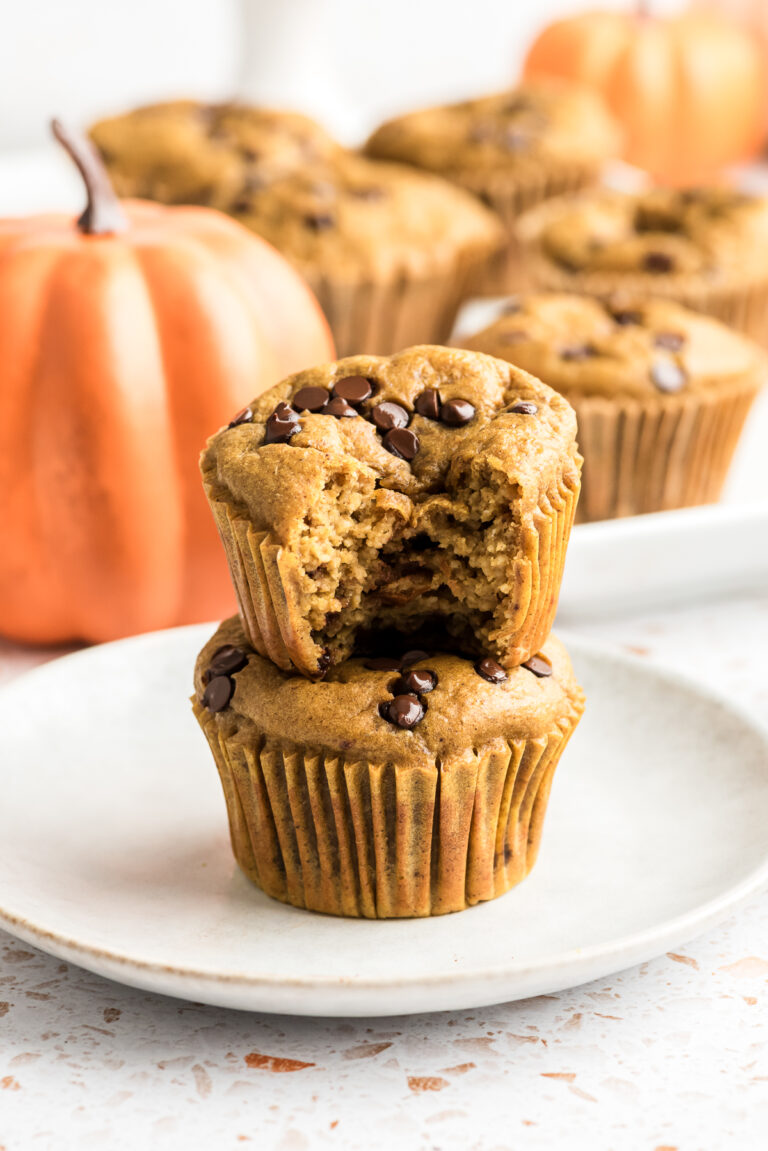 Cottage cheese pumpkin muffin with a bite taken out of it on top of another muffin.