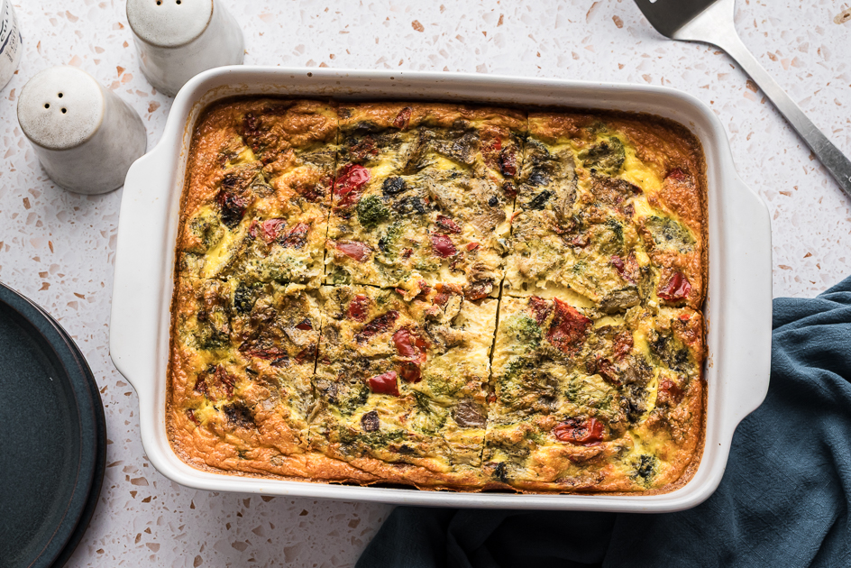 Cottage cheese egg bake in white casserole dish with blue napkin on the side.