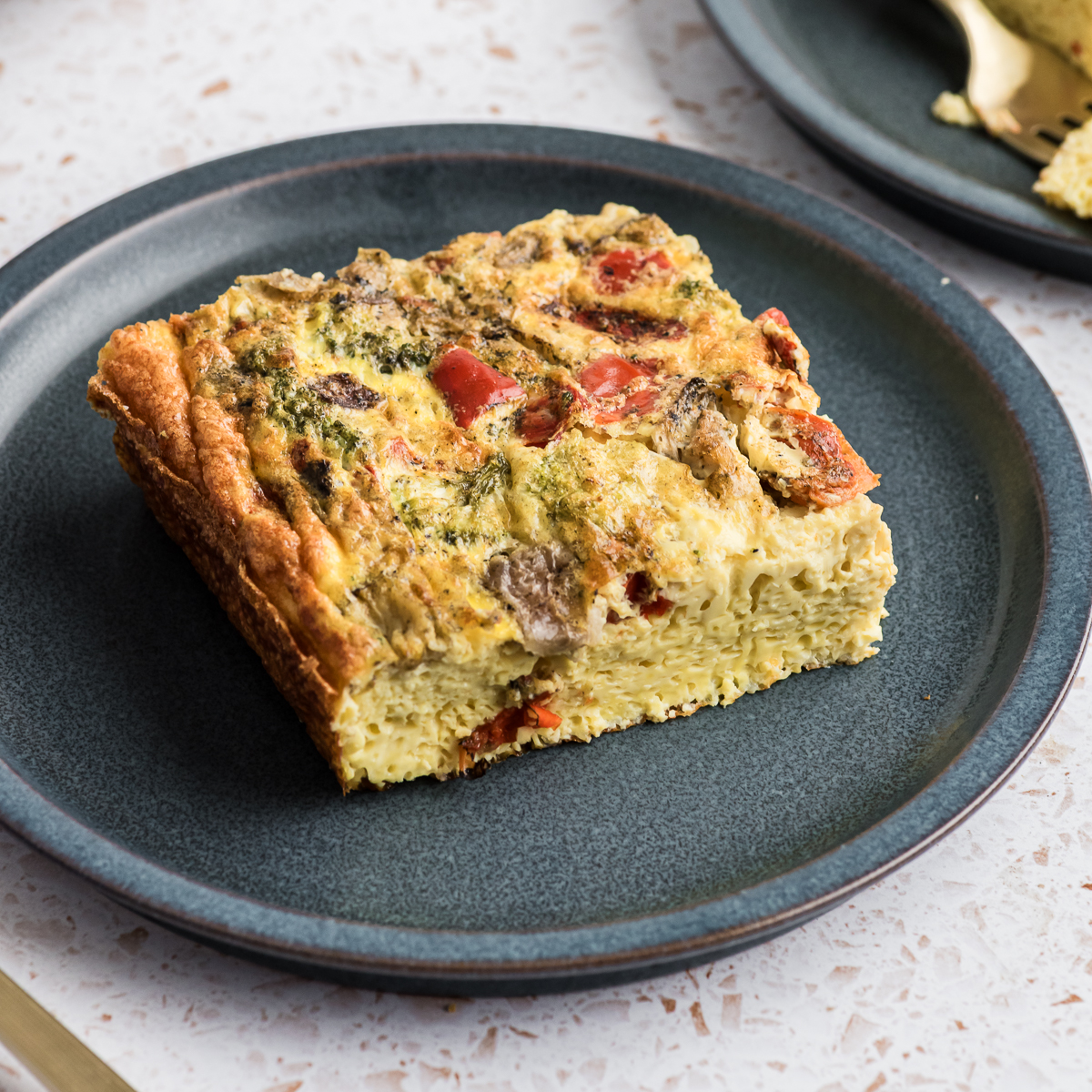 Cottage cheese egg bake slice on a blue plate.