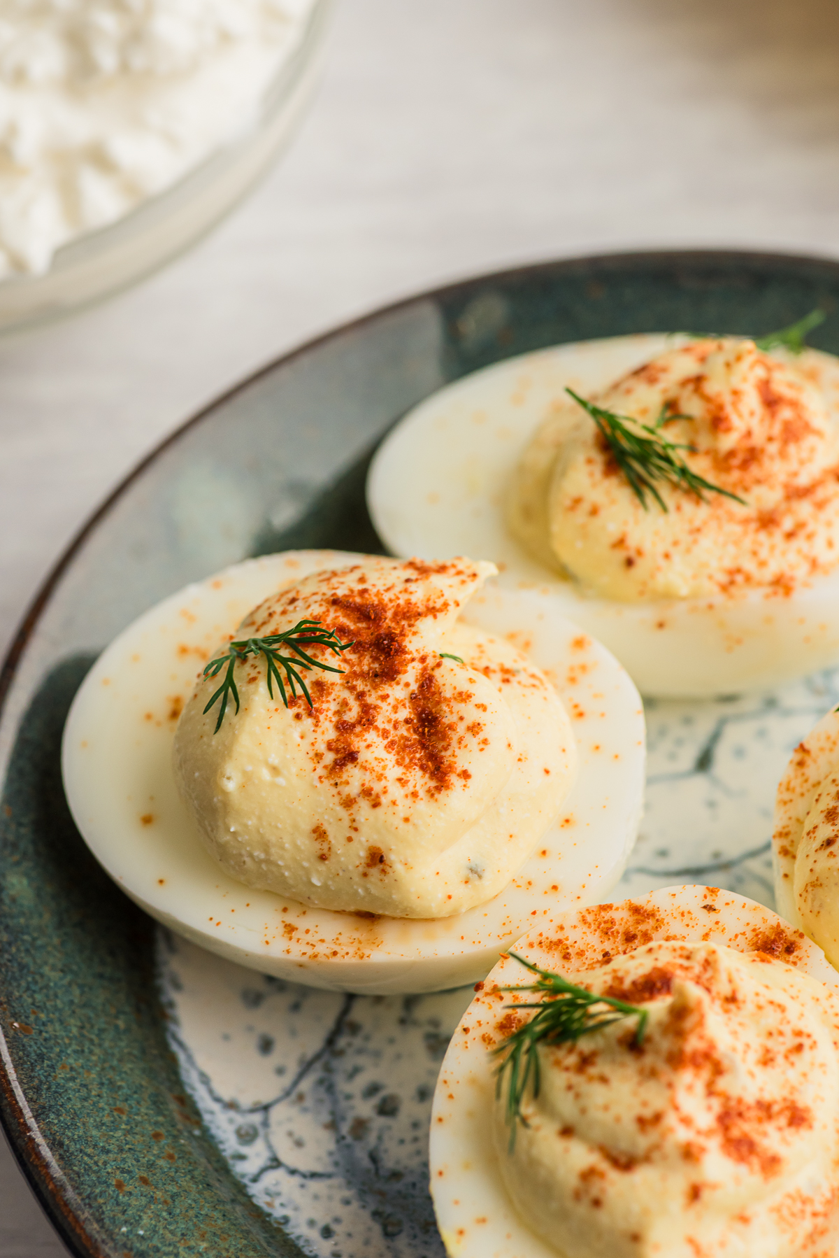 Close up of a cottage cheese deviled egg on a green plate.